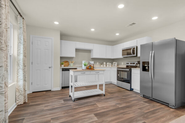 The open kitchen of the Addison floorplan by Holiday Builders is from our Value collection in the Gulf region.
