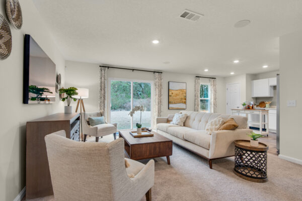 The living room and kitchen of the Addison floorplan by Holiday Builders is from our Value collection in the Gulf region.