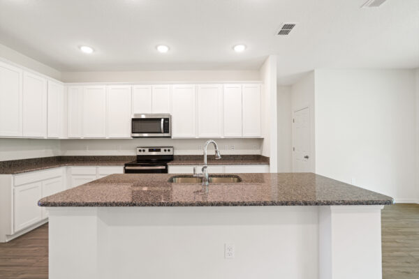 The kitchen in the Cedar floorplan from the Cornerstone collection by Holiday Builders.