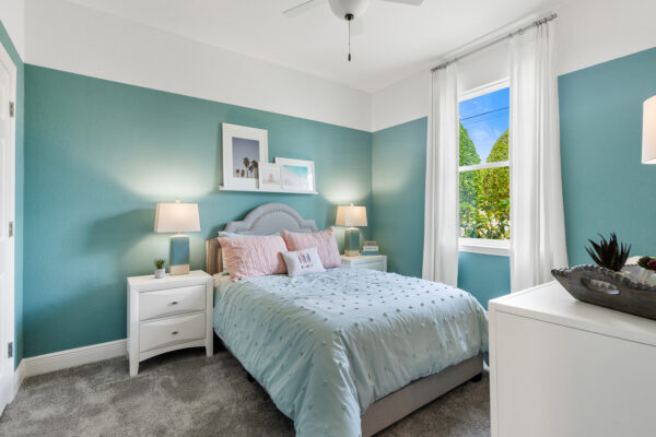 A light teal girl's bedroom in the Charlotte floorplan from the Cornerstone collection by Holiday Builders.