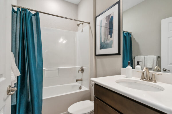 A teal themed guest bath in the Charlotte floorplan from the Cornerstone collection by Holiday Builders.