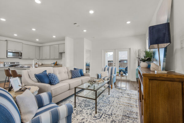 The living area and kitchen in the Cypress floorplan from the Cornerstone collection by Holiday Builders.