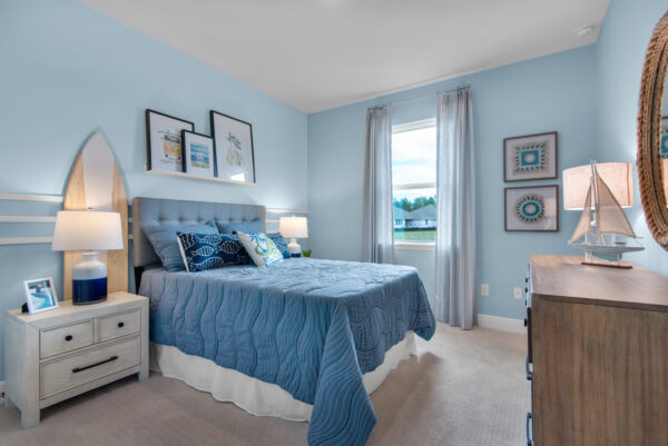 A surf themed bedroom in the Hamilton floorplan from the Cornerstone collection by Holiday Builders.