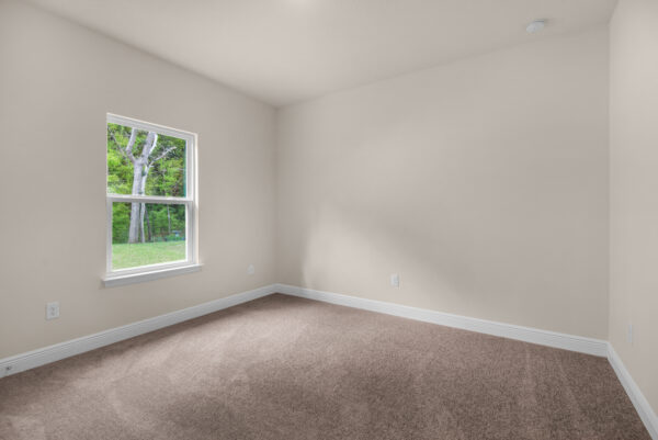 The guest bed in the Rosemary floorplan from the Cornerstone Collection by Holiday Builders.