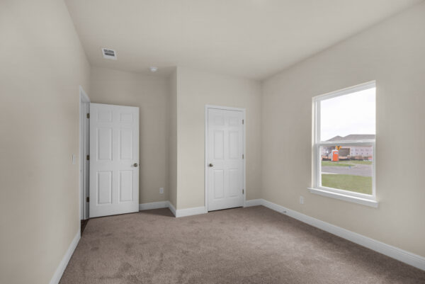 The guest bed in the Walton floorplan from the Cornerstone Collection by Holiday Builders.